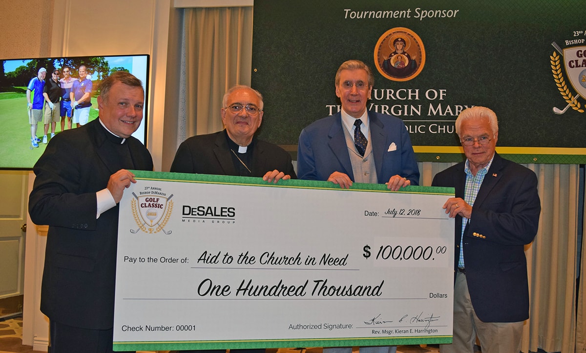 Bishop DiMarzio, a priest and two men holding an oversized check