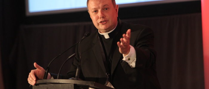 Priest speaking at podium