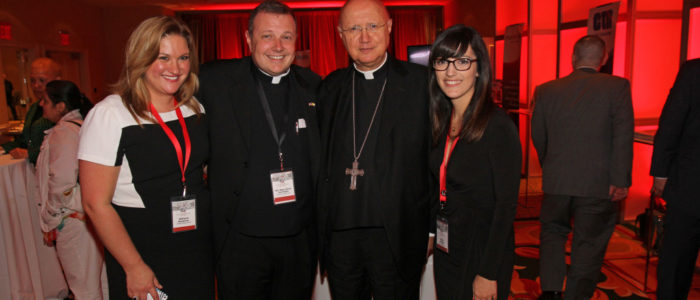 two priests and two women posing for a picture