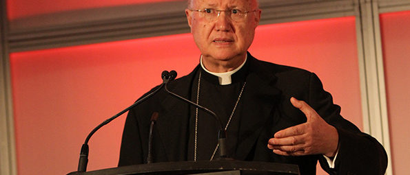 Priest speaking at a podium